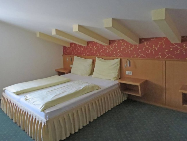 Schlafzimmer mit Doppelbett in der Mansarde