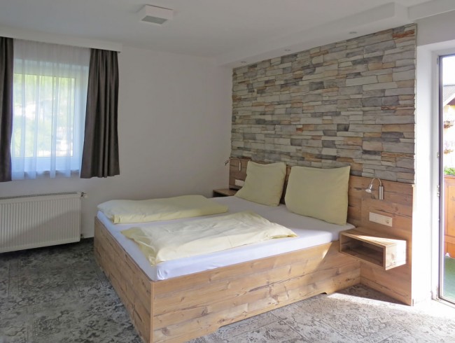 Schlafzimmer mit Steinwandoptik